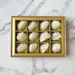 The NutJob White Chocolate Coated Dates with Stuffed Almonds Covered in Coconut Shreds - 12 pieces