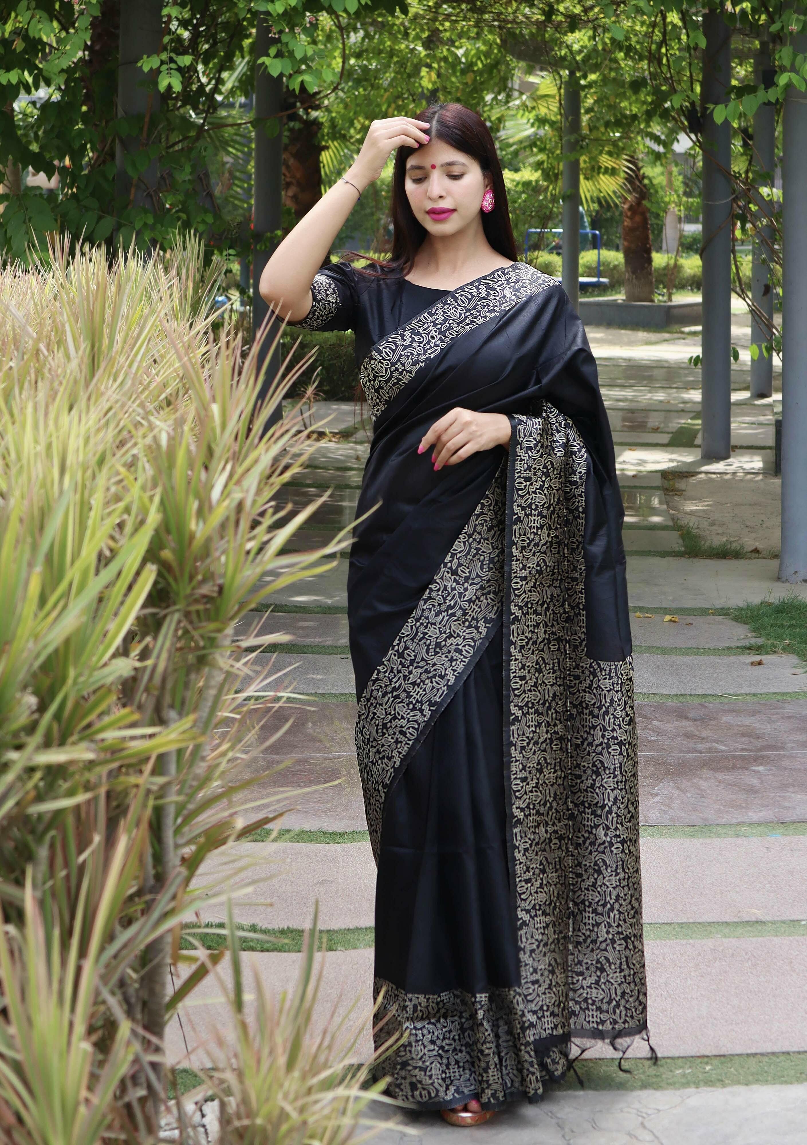 black pure katan silk saree. paired with ivory embroidered cowl top with  embroidered velvet tie-knot belt Design by Neha & Tarun at Modvey | Modvey